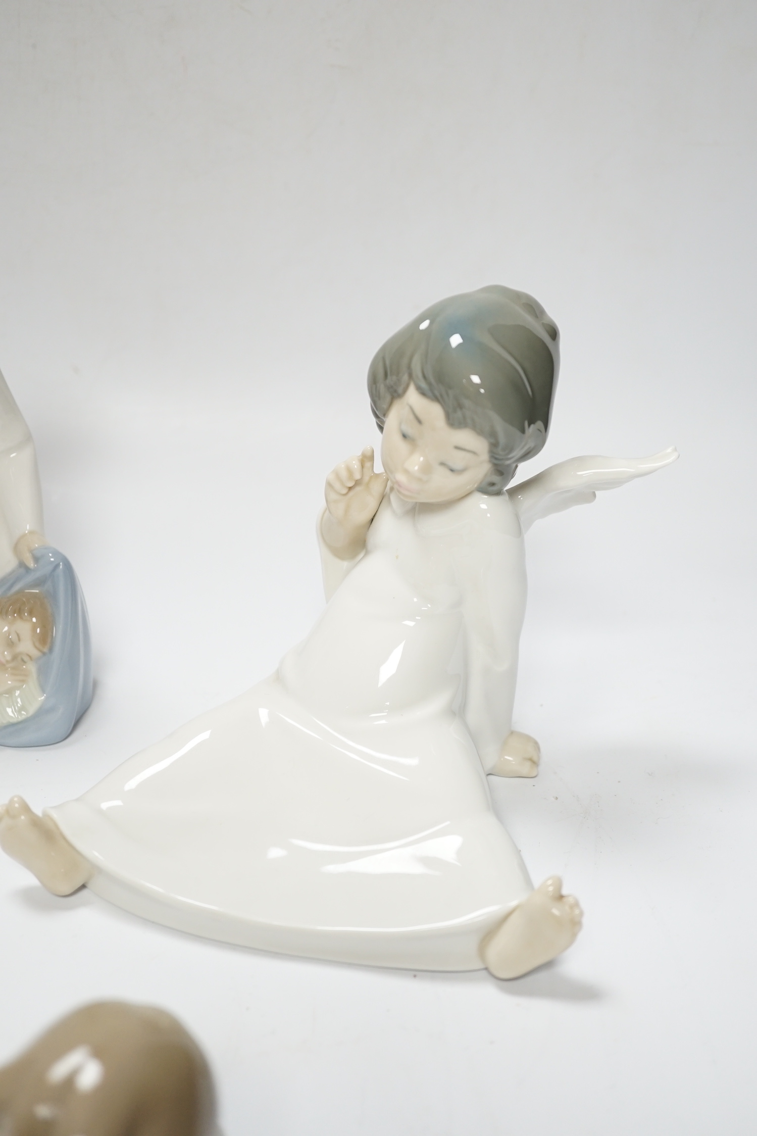 Five Lladro figures; two angelic, two nativity, one of a sleeping child and another of a girl with a lamb, all in boxed, largest 17cm high